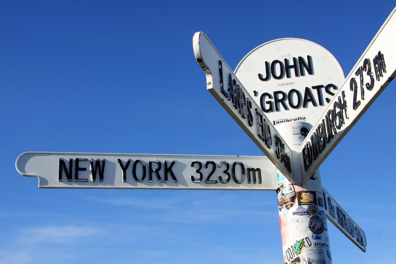 Cyclists at Land’s End signpost starting LEJOG challenge